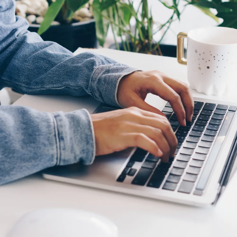 Person using a laptop to study on work desk